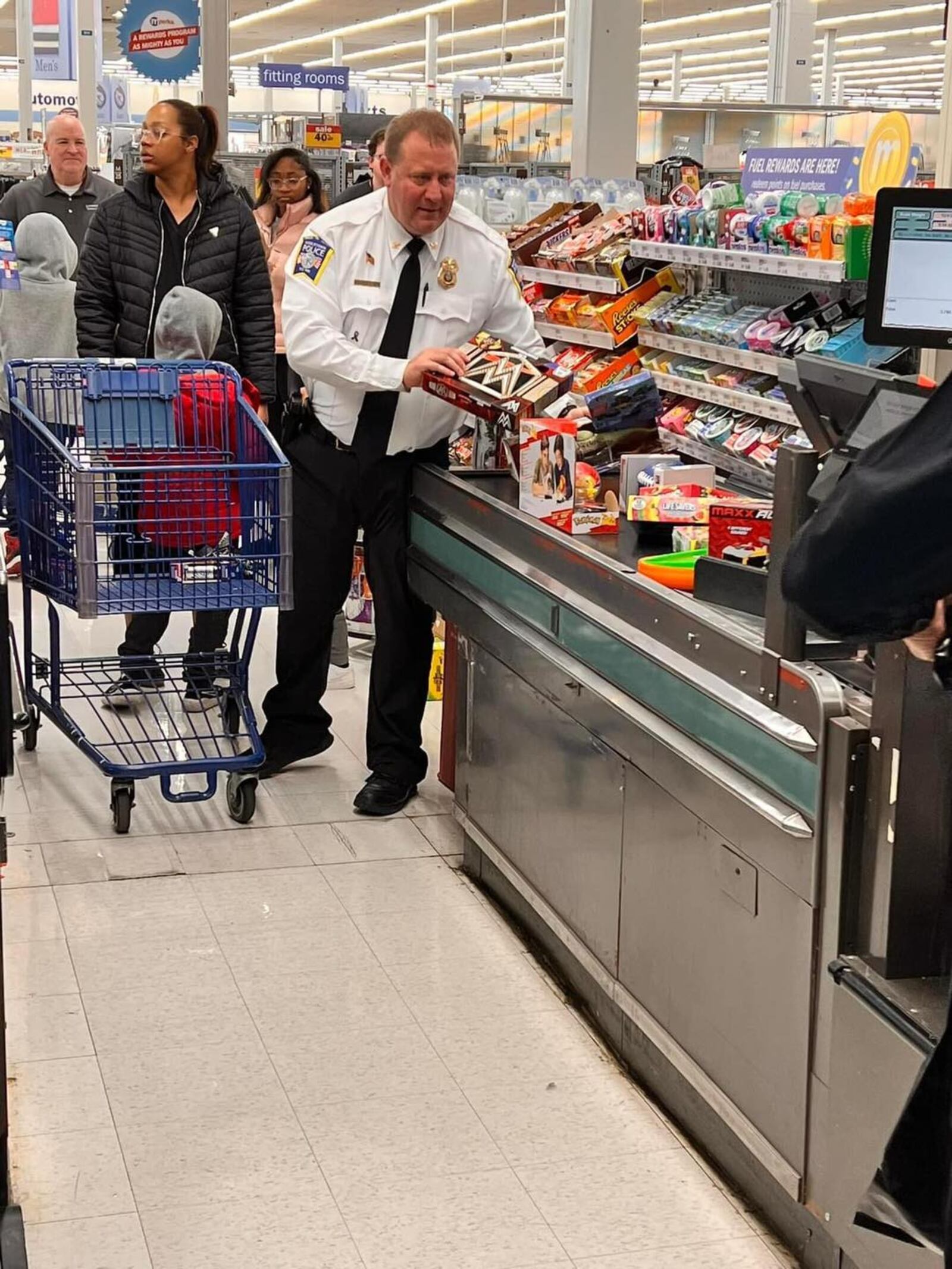 Middletown police Chief David Birk helps some of the children check-out at Meijer recently during the Mike Davis Christmas with a Cop program. SUBMITTED PHOTO