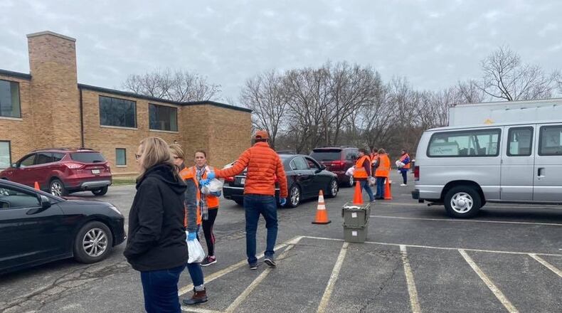 Area school parents by the thousands are making a daily stop at local schools to pick up free student meals their children would normally get if schools were in session. School districts in Butler and Warren County saw officials scramble to get food out to students who need it. Pictured here are Kings Schools teachers, staffers and volunteers handing out student meals. (Provided Photo/Journal-News)