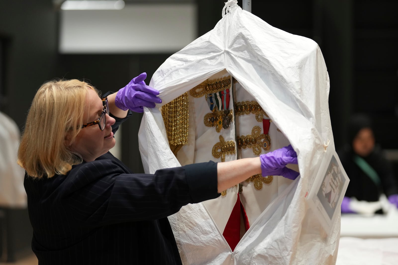 Kate Parsons, Director of Collections Care and Access, shows a costume worn by Elton John on his 1981 world tour, at the V&A Storehouse in London, Thursday, June 5, 2025, the jacket was designed by Bob Mackie. (AP Photo/Joanna Chan)