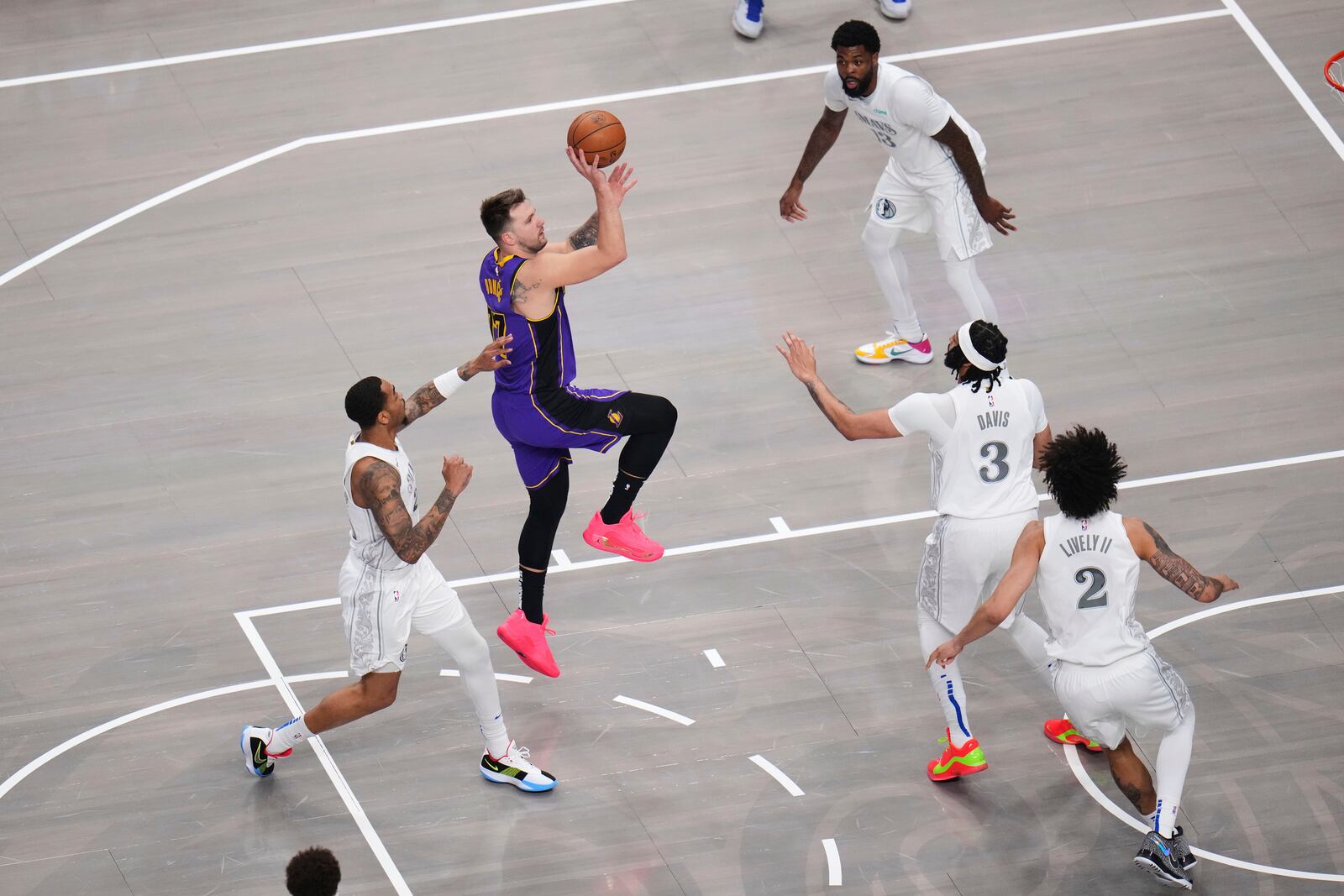Los Angeles Lakers guard Luka Doncic shoots over Dallas Mavericks' Anthony Davis (3) and Dereck Lively II (2) in the first half of an NBA basketball game in Dallas, Wednesday, April 9, 2025. (AP Photo/Julio Cortez)