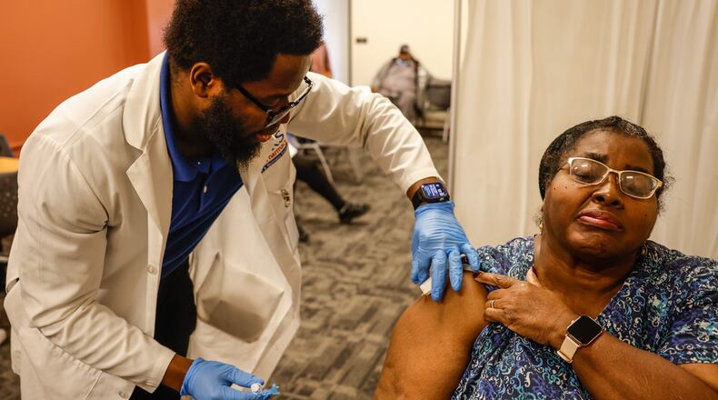 Lisa Tingle, from Dayton, receives a flu shot from Ziks Clinical Pharmacist, Emmanuel Ayanjoke at the store Friday Dec. 3, 2021. Flu vaccines are urged ahead of Christmas time gatherings and to help prevent twin surges of flu and COVID-19. JIM NOELKER/STAFF