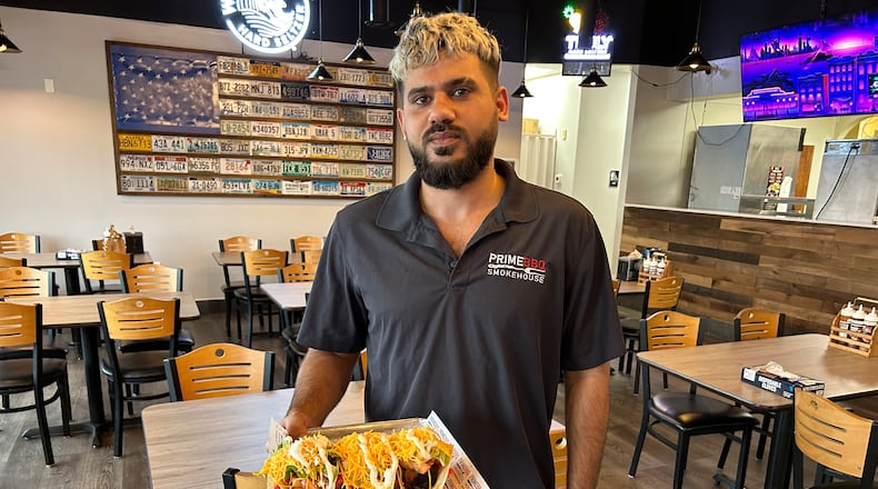Nawaf Nayyef from Prime BBQ Smokehouse in Monroe delivers a plate of tacos to a customer. The restaurant has added to its menu, including three tacos on Taco Tuesdays for $8.99. RICK McCRABB/STAFF