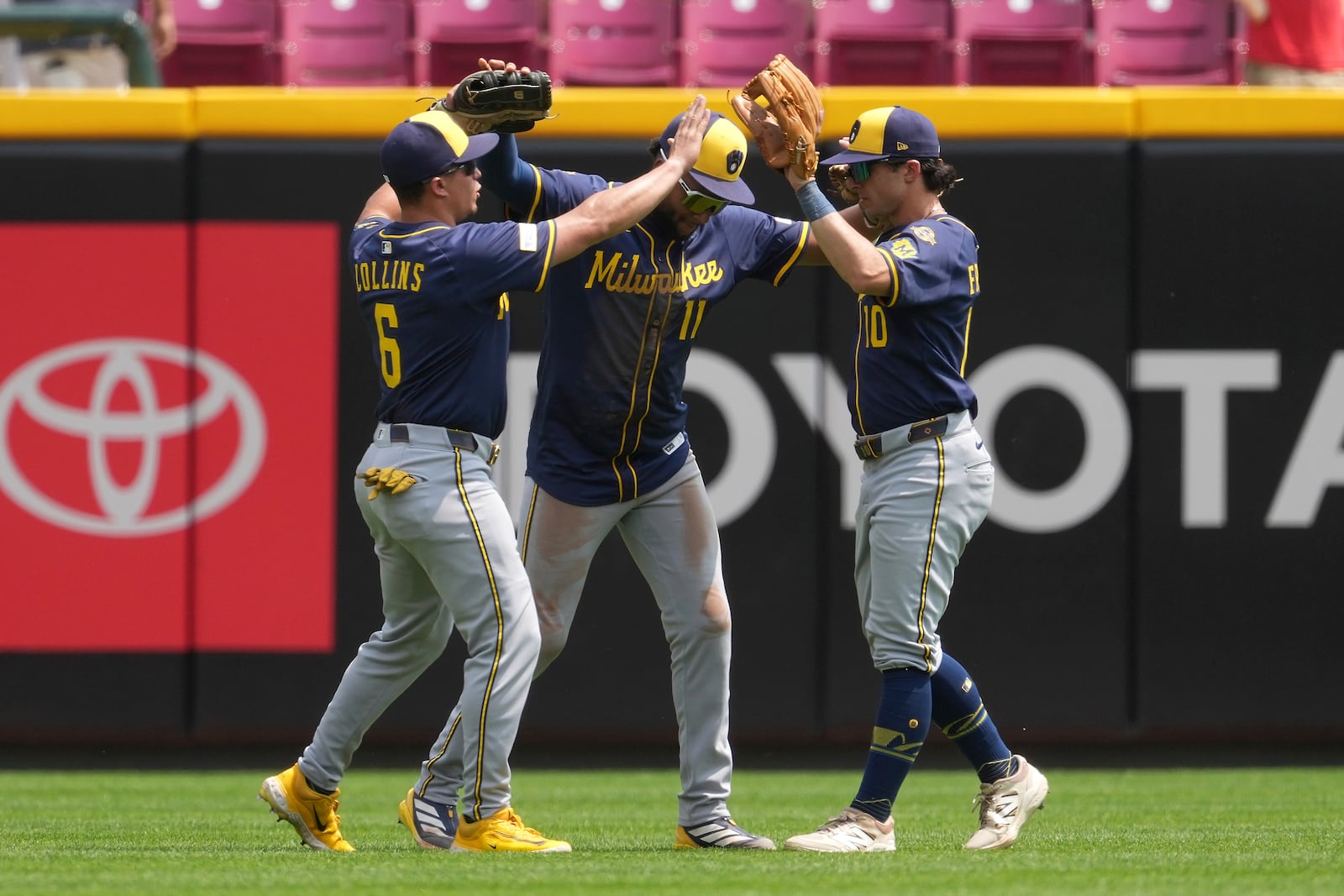 Milwaukee Brewers players, from left, Isaac Collins, Jackson Chourio and Sal Frelick celebrate in the outfield at the conclusion of a baseball game against the Milwaukee Brewers, Wednesday, June 4, 2025, in Cincinnati. (AP Photo/Kareem Elgazzar)