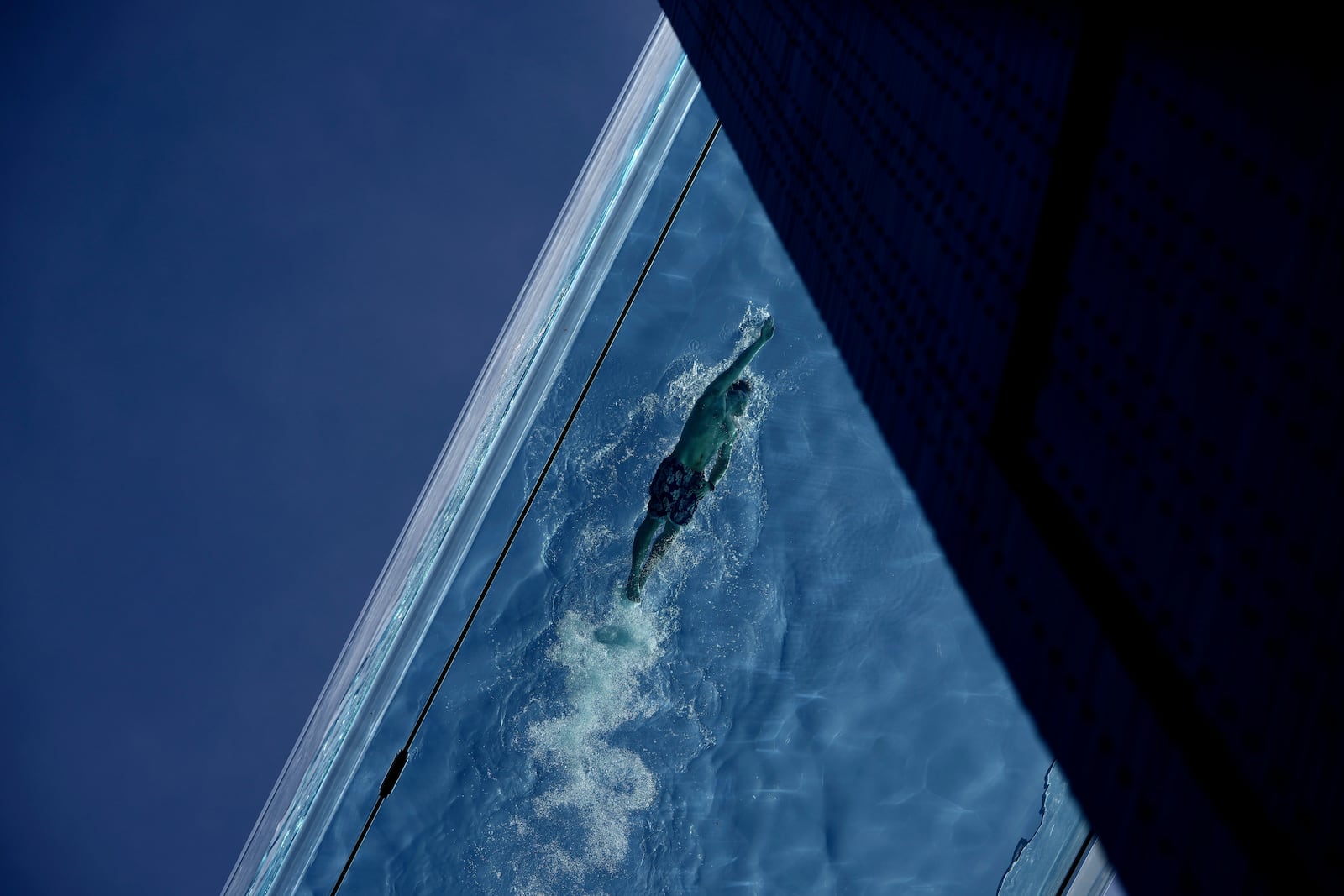 A man swims in the Sky Pool on a sunny day in London, Thursday, May 1, 2025. (AP Photo/Kin Cheung)