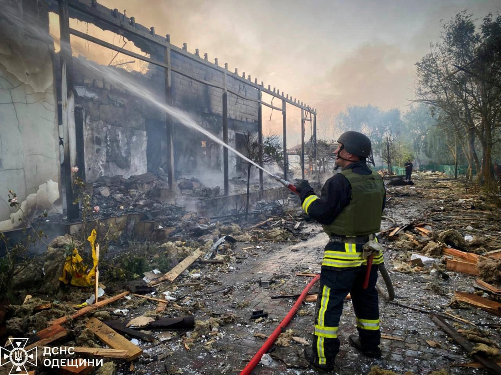 In this photo provided by the Ukrainian Emergency Service, a firefighter tackles a blaze after a Russian attack that hit a private house in Odesa region, Ukraine, Wednesday, June 11, 2025. (Ukrainian Emergency Service via AP)