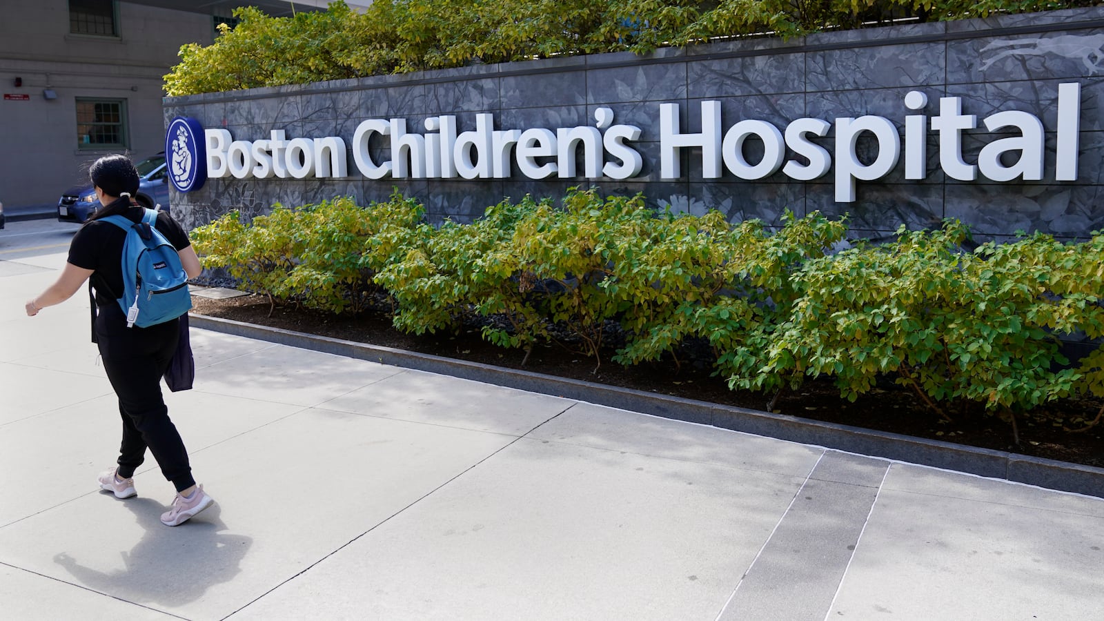 FILE — A woman walks past a sign outside the Boston Children's Hospital, Aug. 18, 2022, in Boston. (AP Photo/Charles Krupa, File)