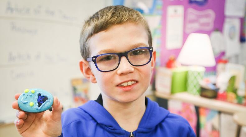 Mason Kelley, a fourth-grader at Fairwood Elementary School shows one of the rocks he decorated as part of a class project. Rocks painted with inspirational messages will be left around the city to raise the spirits of those who find them. GREG LYNCH / STAFF