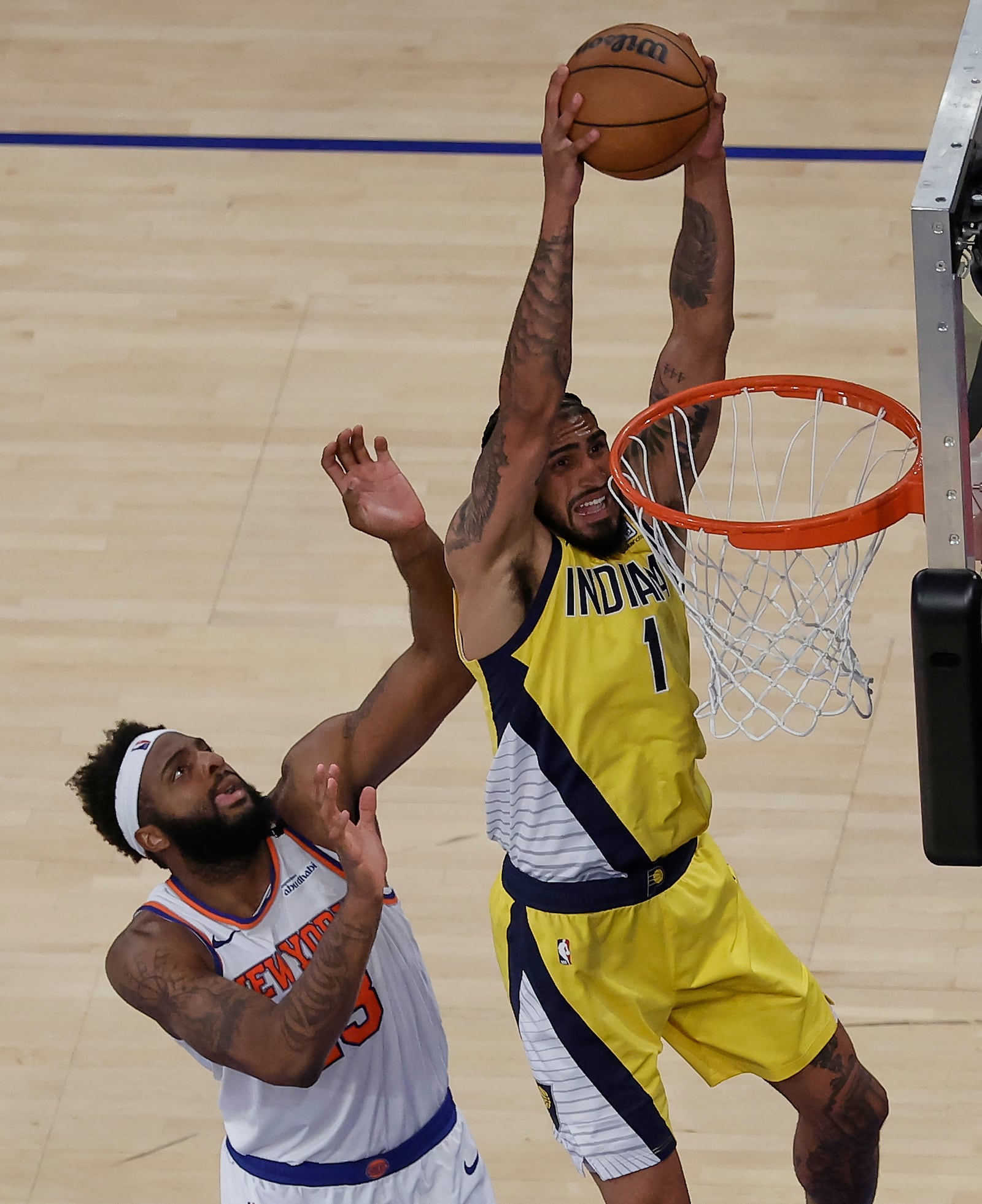 Indiana Pacers forward Obi Toppin (1) dunks the ball against New York Knicks center Mitchell Robinson (23) in overtime of Game 1 of the NBA basketball Eastern Conference final, Wednesday, May 21, 2025, in New York. (AP Photo/Adam Hunger)