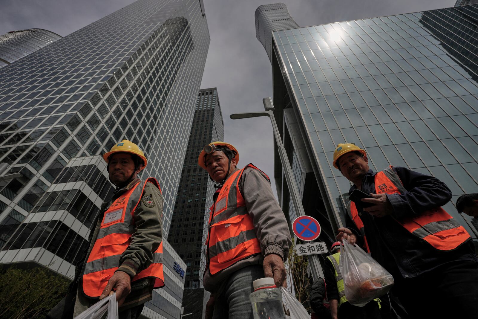 Construction workers buy their lunch meals near the high rise office buildings in the central business district, in Beijing, Tuesday, April 8, 2025. (AP Photo/Andy Wong)