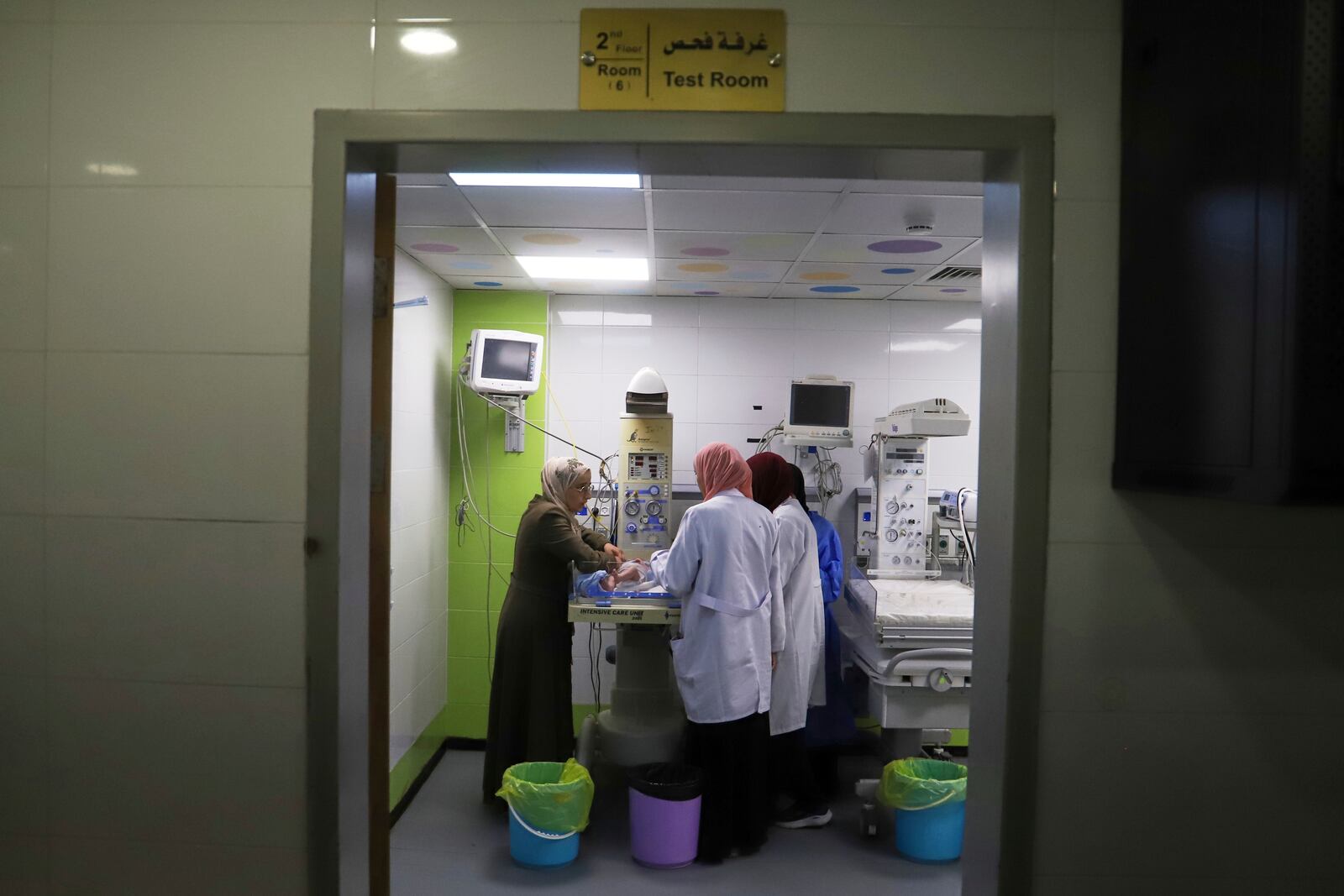 A mother watches as her prematurely born baby is examined at the neonatal intensive care unit of Nasser Hospital in Khan Younis, southern Gaza Strip, Thursday, June 19, 2025. (AP Photo/Mariam Dagga)