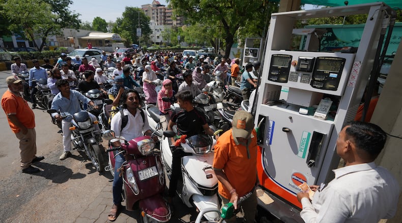 Motorists queue up to get fuel at a pump, fearing a possible fuel shortage due to the US Iran war, in Ahmedabad, India, Monday, March 23, 2026. (AP Photo/Ajit Solanki)