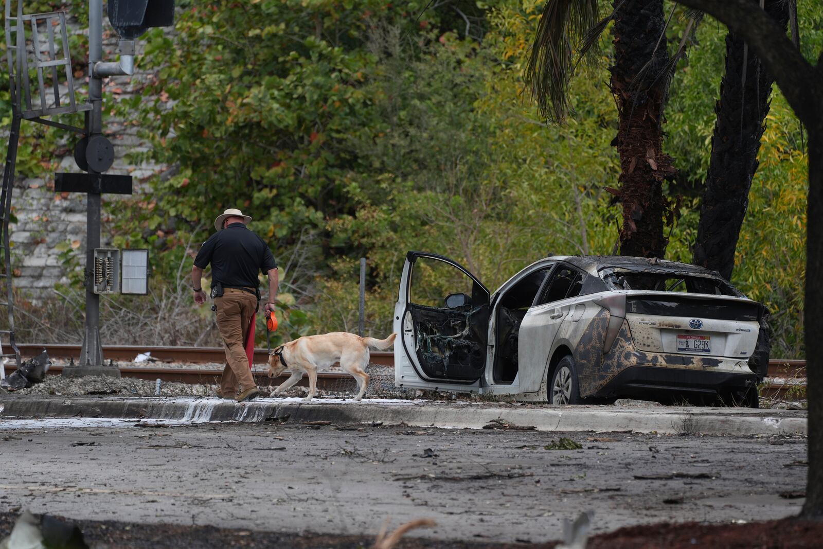 Emergency personnel respond to the area where a small plane crashed on the railroad tracks beneath the overpass near Interstate 95 in Boca Raton, Fla., on Friday, April 11, 2025. (AP Photo/Marta Lavandier)