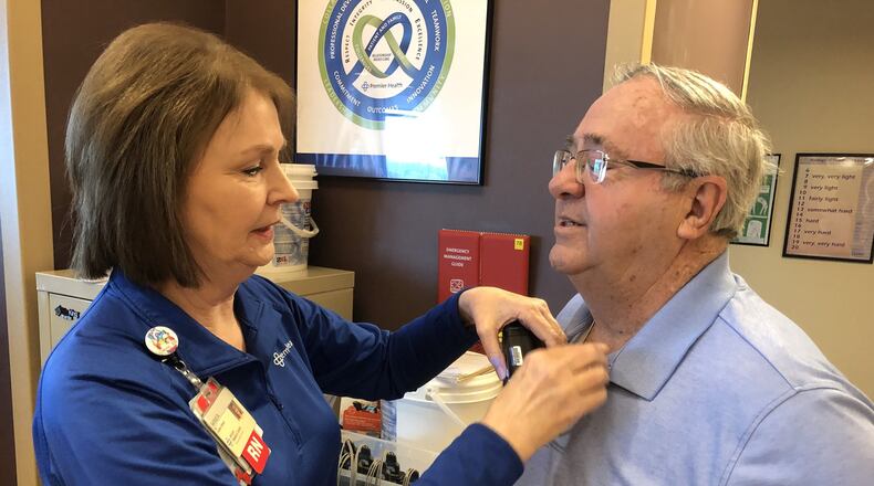 Registered nurse Gayle DeBord, former director of the Atrium Medical Center cardiac rehabilitation unit, tests Fred Gibson before a recent exercise session. He had open-heart surgery 10 years at Atrium and attends rehab three days a week. RICK McCRABB/STAFF