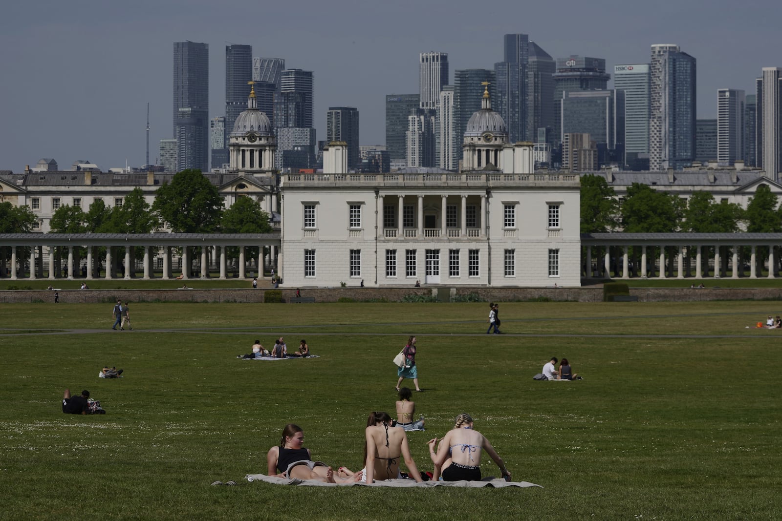 People sunbathe on a sunny day at a park in London, Thursday, May 1, 2025. (AP Photo/Kin Cheung)