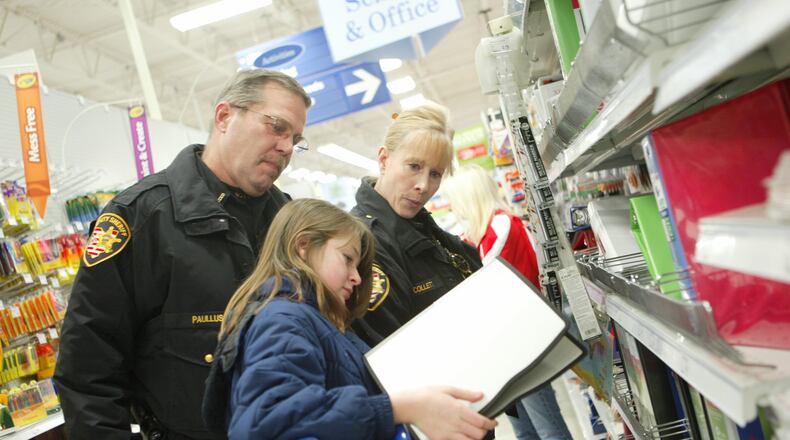 Butler County Deputy Dale Paullus and Lt. Jean Collett shop with New Miami student Katielyn Spears,12 as she looks for drawing supplies for her brother. Meijer in Fairfield donated funds for a “Shop with a Cop” held at the store Monday, Dec. 22, 2008. Staff photo by Linda Weisenborn