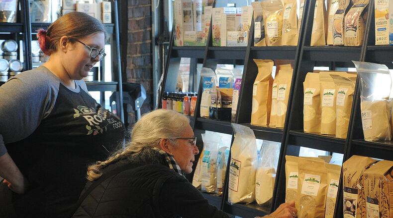 Samantha Lange, left, with Rosebud's Real Food at the 2nd Street Market helps Catherine Hackett with her shopping Friday, Dec. 15, 2023. MARSHALL GORBY\STAFF