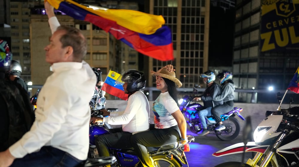 Opposition leaders María Oropeza and Juan Pablo Guanipa, left, ride motorbikes through Caracas, Venezuela, after their release from custody, Sunday, Feb. 8, 2026. (AP Photo/Ariana Cubillos)