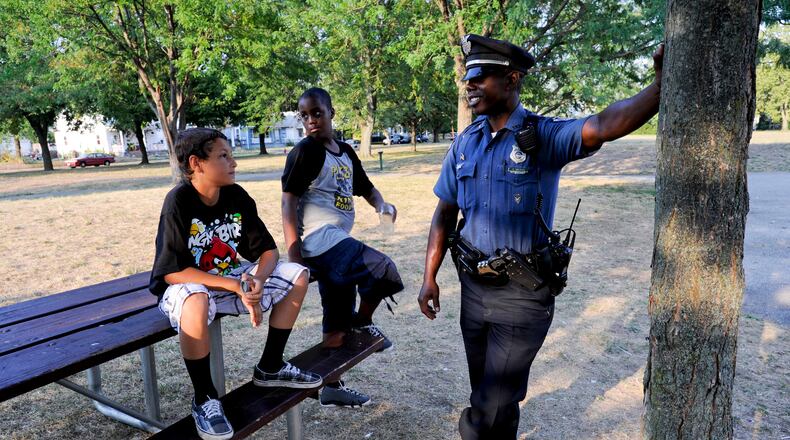 Middletown Police officer Earl Nelson talks to Jaden Thomas, 10, left, and Kayron Edwards, 12, as he patrols the Sherman Park area Friday, Aug. 3, 2012 in Middletown. Staff photo by Nick Graham
