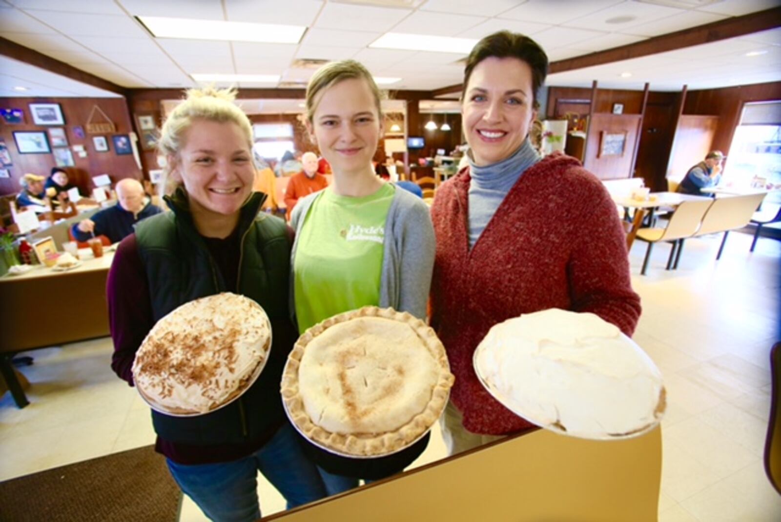 Tarin Lauer, Audrey Amburgy, and Co-owner Amy Hyde-Klaiber stand with coconut, apple and banana cream pies at Hydes Restaurant in Hamilton on Pi Day, Tuesday, Mar. 14. GREG LYNCH/STAFF