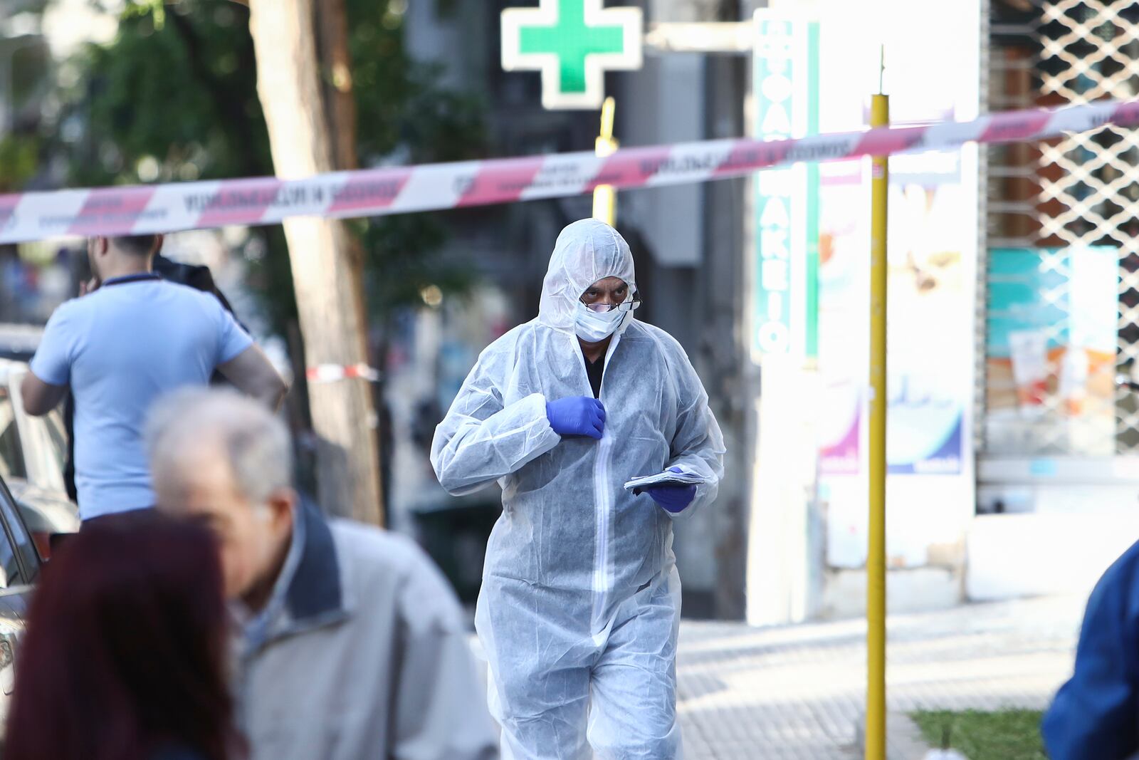 A Greek police forensic expert searches for evidence at the area where a 38-year-old woman was killed early Saturday when a bomb she was carrying exploded in her hands outside a bank branch, local police said, in Thessaloniki, northern Greece, May 3, 2025. (AP Photo/Giannis Papanikos)