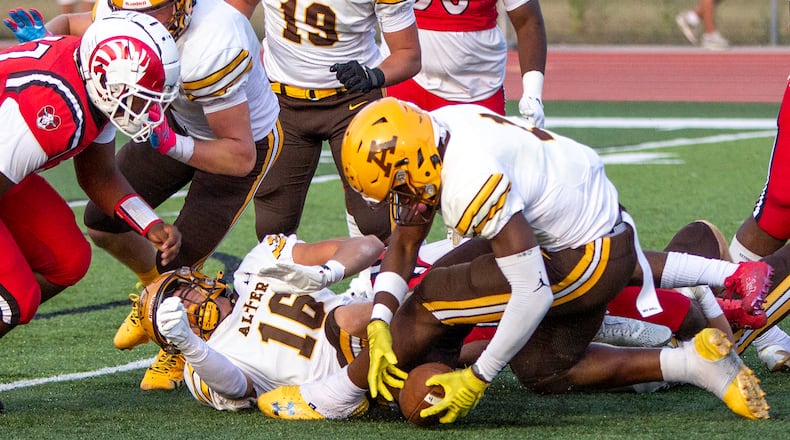 Alter's Okemdi Eze recovers a fumble by Trotwood-Madison Daylan Dennis that was forced by quarterback Morgan Montgomery (16) in Thursday night's 10-7 Alter win. Jeff Gilbert/CONTRIBUTED