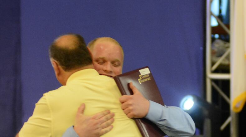 Johnny Astrop, a Navy veteran from West Chester Twp., hugs his dad, John Astrop Thursday, June 28, 2017, after he received his welding technician career passport from the Adult Workforce Development program Great Oaks. MICHAEL D. PITMAN/STAFF