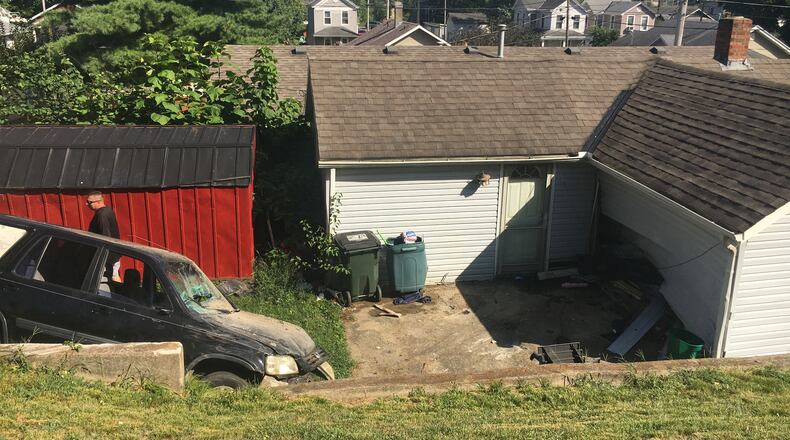 A Honda CR-V crashed into a house near the intersection of Lagonda Avenue and Summer Street Wednesday afternoon in Hamilton. MIKE RUTLEDGE/STAFF