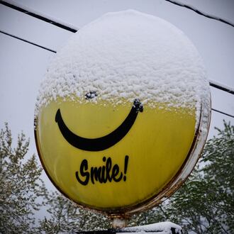 A sign near Fairborn is half covered with snow on April 21, 2021. A winter storm is forecast to move through the southern and eastern part of the country this weekend and could bring accumulating snow to the Miami Valley. STAFF/FILE