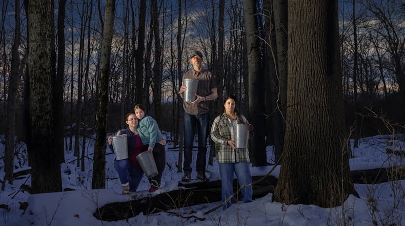 Kristina and Adeline Fox, George Ironstrack and Kara Strass of the Miami Tribe of Oklahoma among Black Maples in Oxford, holding buckets used to gather sap from surrounding maple trees. Photo by Tina Gutierrez, 2025. CONTRIBUTED