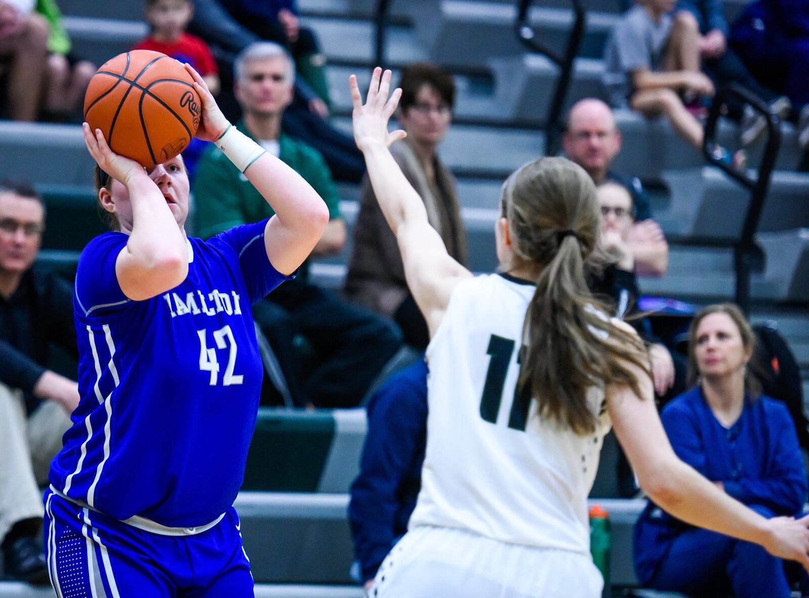 Hamilton’s Sam Fuller takes a shot as Badin’s Emily Maher provides the defense in Monday night’s game at Mulcahey Gym in Hamilton. NICK GRAHAM/STAFF