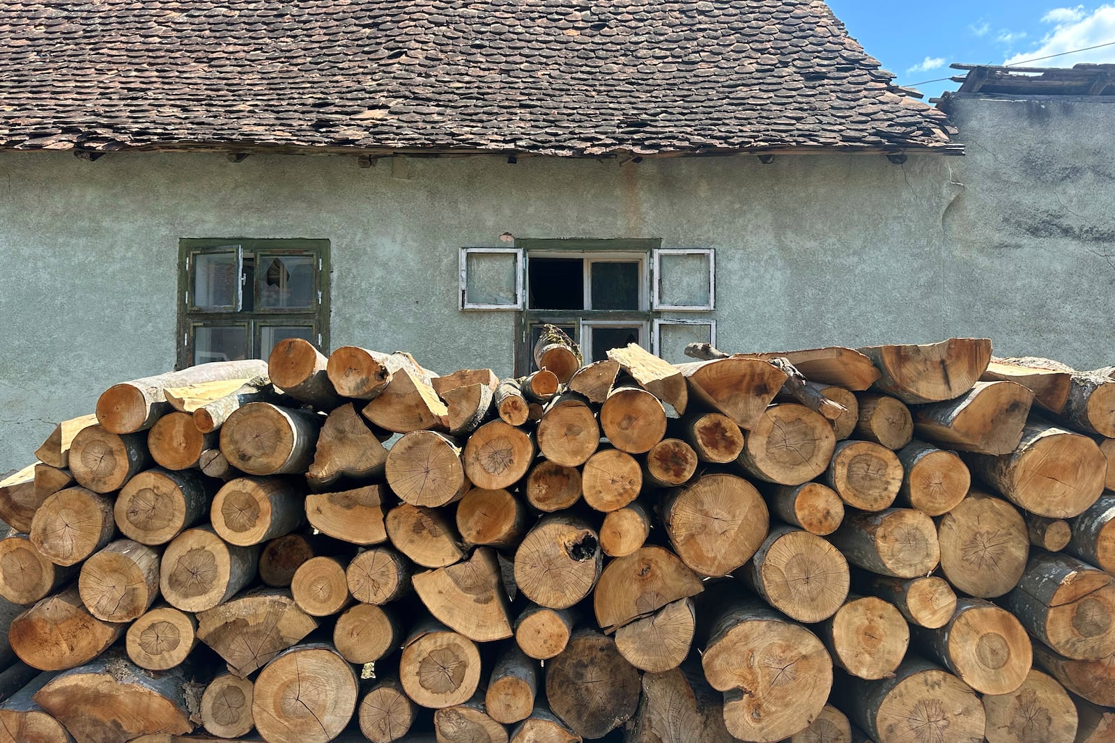 Firewood is stacked outside a house in the village of Saschiz, in Romania's central Transylvania region, Friday, April 25, 2025. (AP Photo/Stephen McGrath)