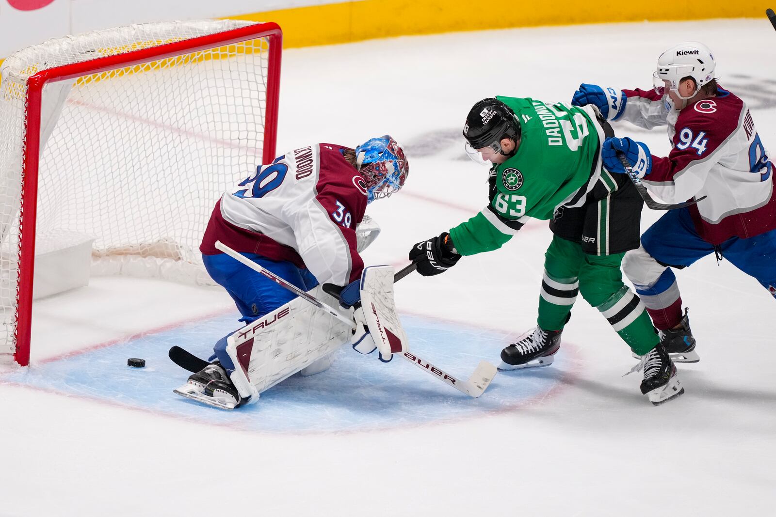 Dallas Stars right wing Evgenii Dadonov (63) sneaks the puck by Colorado Avalanche goaltender Mackenzie Blackwood (39) for a goal as left wing Joel Kiviranta (94) tries to defend during the third period in Game 2 of a first-round NHL hockey playoff series Monday, April 21, 2025, in Dallas. (AP Photo/Julio Cortez)