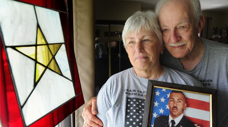 Jim and Leslie Groves embrace a photo of their son, US Army Chief Warrant Officer James E. Groves III. Groves was killed in Afghanistan in 2013 when he was 37, He was assigned to 3rd Squadron, 17th Cavalry Regiment, 3rd Combat Aviation Brigade, 3rd Infantry Division Hunter Army Airfield, Ga.; died March 16 in Kandahar, Afghanistan, in an OH-58 Kiowa helicopter crash.. MARSHALL GORBY\STAFF