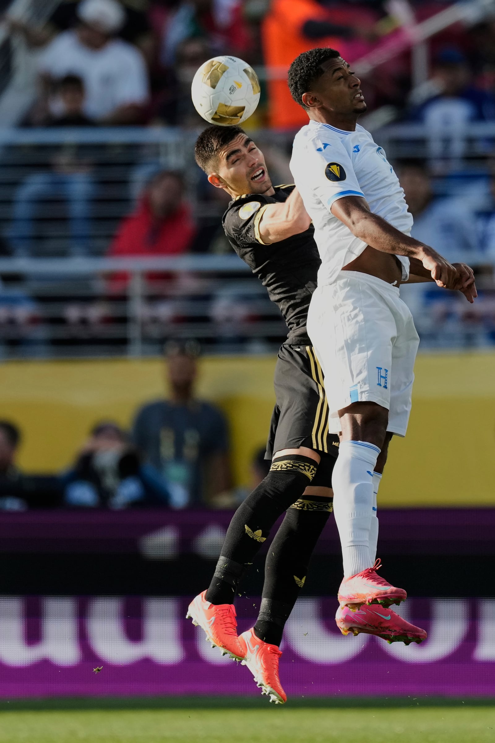 Mexico defender Johan Vásquez, left, and Honduras forward Choco Lozano jump for the ball during the first half of a CONCACAF Gold Cup semifinal soccer match Wednesday, July 2, 2025, in Santa Clara, Calif. (AP Photo/Godofredo A. Vásquez)