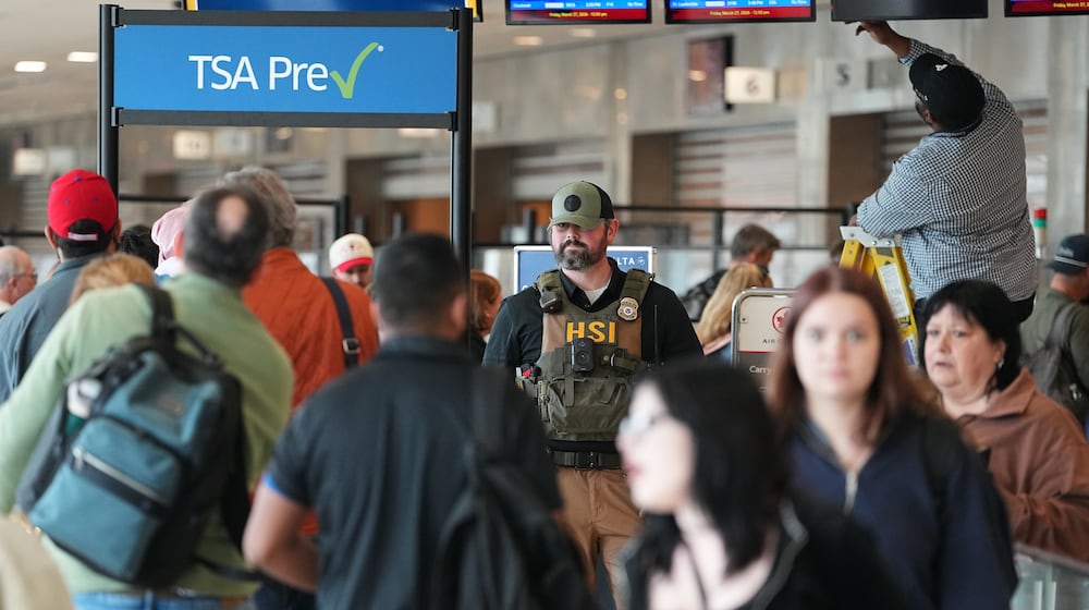A federal officer, stands at a Transportation Security Administration (TSA) checkpoint at Philadelphia International Airport in Philadelphia, Friday, March 27, 2026. (AP Photo/Matt Rourke)