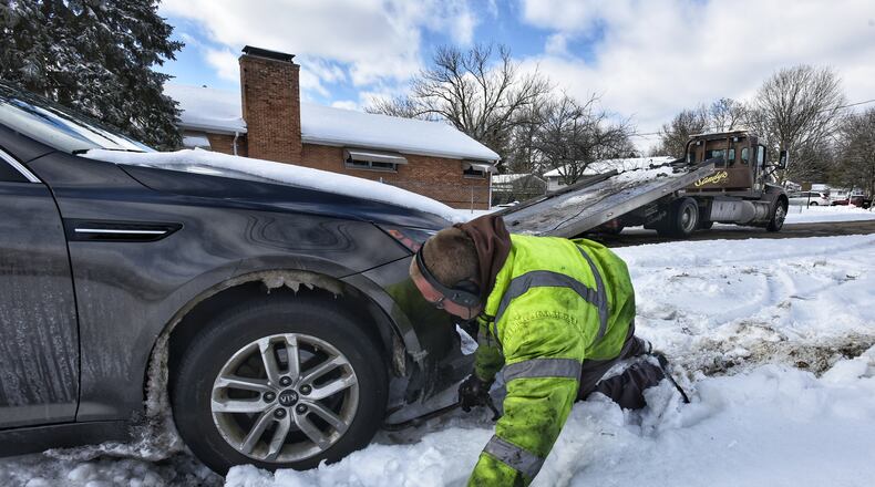 Will Lemke, with Sandy's Towing, pulls a car parked along Curryer Road out of the snow Tuesday, February 16, 2021 in Middletown. NICK GRAHAM / STAFF