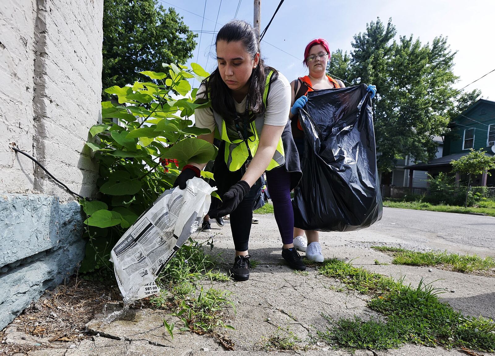 Brianna Valdez, 17, left, and Lotus Emison, 19, along with a group of nearly fifty people with HYPE Hamilton youth mentoring program, led by pastor Shaquila Mathews, cleaned up trash as a community service Thursday, July 28, 2022 in Hamilton. NICK GRAHAM/STAFF