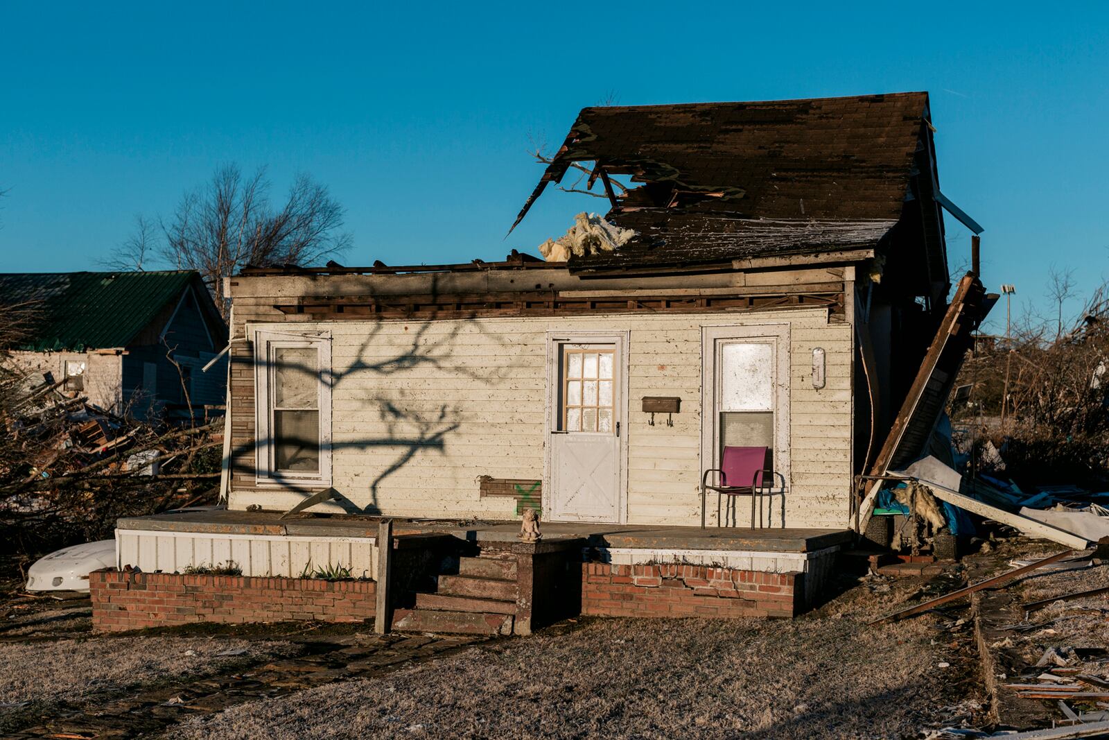 A home is missing a portion of the roof in Dawson Springs, Ky., on Monday, Dec. 13, 2021, where a tornado flattened much of the town on Friday night. After grimly fluctuating death tolls since Friday’s devastating swarm of tornadoes, Gov. Andy Beshear of Kentucky said on Monday that there were 64 confirmed deaths in the state, though he expected that number to rise as crews continued to search through the ruins. (William Widmer/The New York Times)
