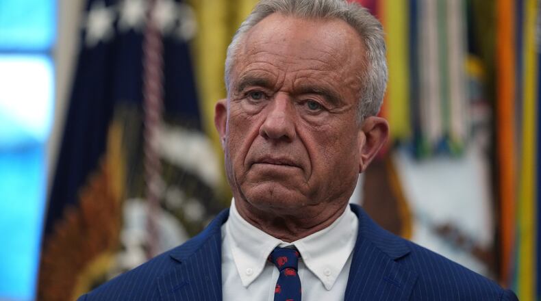 Health and Human Services Secretary Robert F. Kennedy Jr. listens as President Donald Trump speaks at an event on addiction recovery in the Oval Office of the White House, Thursday, Jan. 29, 2026, in Washington. (AP Photo/Allison Robbert)
