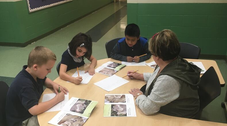Kiser School second-graders work on a writing assignment with a classroom aide last school year. Dayton schools and others that serve many low-income, high-need students have a chance at sharing $35 million in grant money that Ohio will receive. JEREMY P. KELLEY / STAFF