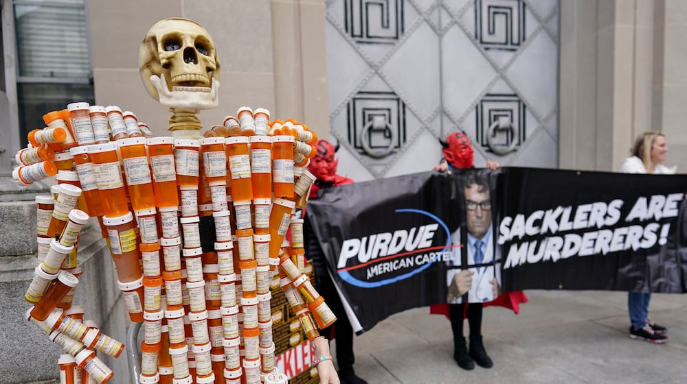 FILE - "Pill Man" made by Frank Huntley of Worcester, Mass., from his opioid prescription pill bottles, is displayed during a protest by advocates for opioid victims outside the Department of Justice, Dec. 3, 2021, in Washington. (AP Photo/Carolyn Kaster, File)