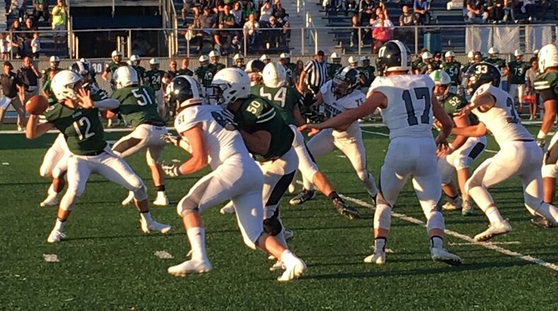 Badin quarterback Jordan Flaig (12) prepares to launch a pass during last Saturday night’s game against Edgewood at Virgil Schwarm Stadium in Hamilton. The visiting Cougars won 28-14. RICK CASSANO/STAFF