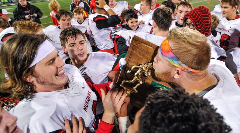 Madison’s players have some fun with the Division V, Region 20 championship trophy after beating West Jefferson 42-7 on Friday night at Beavercreek. NICK GRAHAM/STAFF