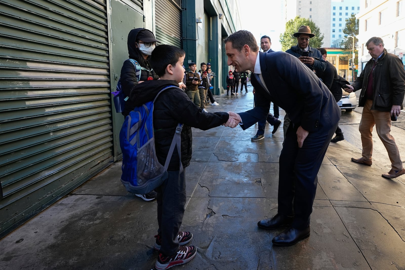FILE - Mayor-elect Daniel Lurie, right, greets a young student while walking through the Tenderloin neighborhood Wednesday, Jan. 8, 2025, in San Francisco. (AP Photo/Godofredo A. Vásquez, File)
