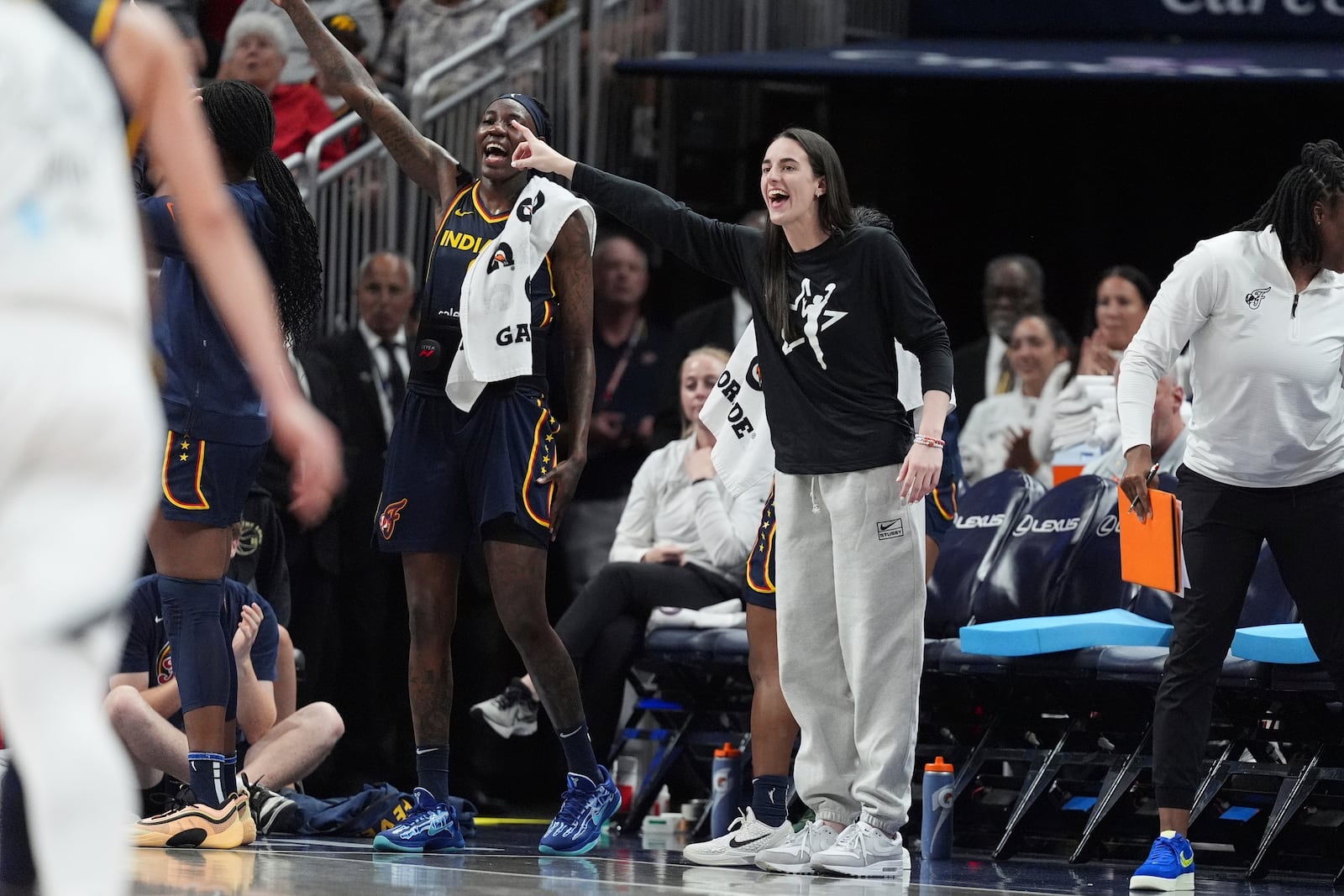 Indiana Fever's Caitlin Clark, right, cheers during the second half of a WNBA basketball game against the Las Vegas Aces, Thursday, July 3, 2025, in Indianapolis. (AP Photo/Michael Conroy)