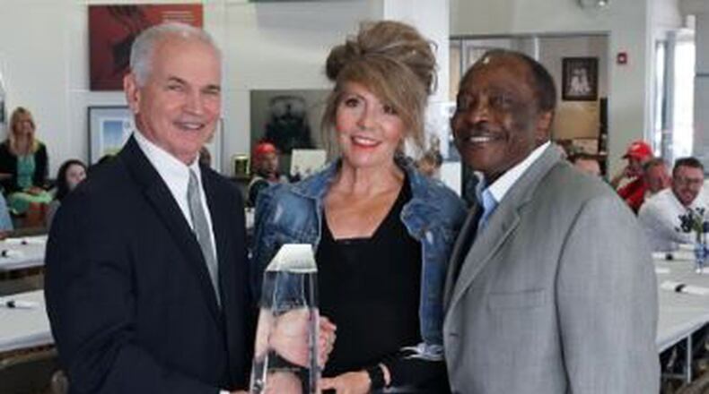 Roger Quandt, American Honda Motor Co. Inc., Central Zone parts and service manager, hands Joe and Teresa Morgan the Honda President s Award on May 16. Joe Morgan Honda in Monroe has won the award for six consecutive years. Contributed photo