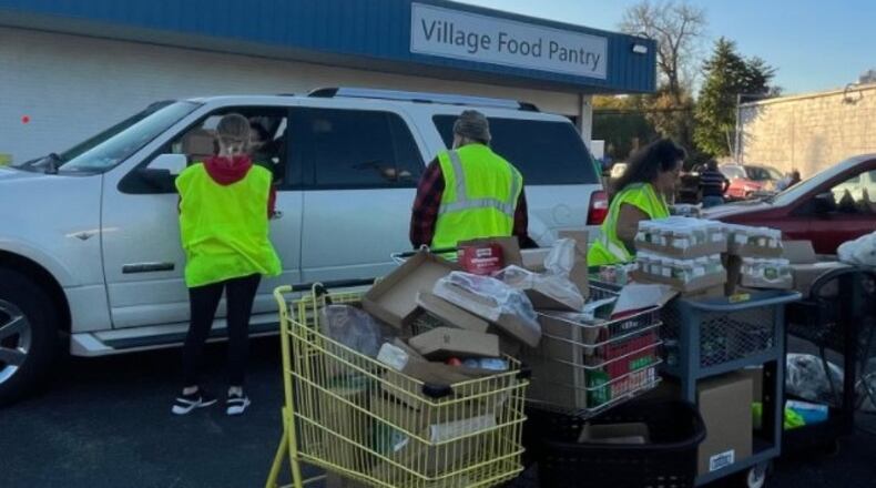 People distribute food at Village Food Pantry on Riverside Drive in New Miami on Wed., Oct. 20, 2022. AVERY KREEMER/STAFF