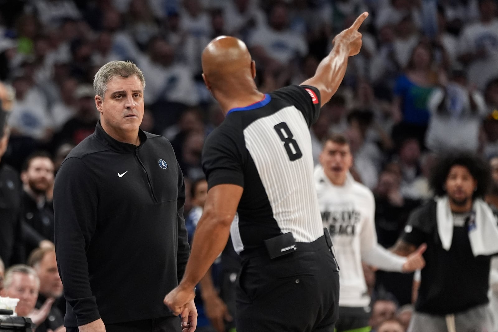 Minnesota Timberwolves assistant coach Micah Nori, left, listens to referee Marc Davis (8) explain a call during the second half of Game 5 of the Western Conference finals in the NBA basketball playoffs against the Dallas Mavericks, Thursday, May 30, 2024, in Minneapolis. (AP Photo/Abbie Parr)