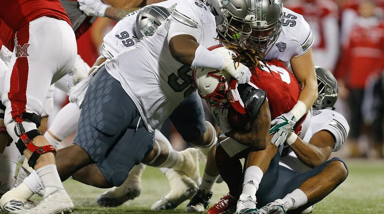 Oddie Granger III #95 and Ville Valasti #55 of the Eastern Michigan Eagles tackle Kenny Young #3 of the Miami Ohio Redhawks during the first half at Yager Stadium on November 15, 2017 in Oxford, Ohio. (Photo by Michael Reaves/Getty Images)