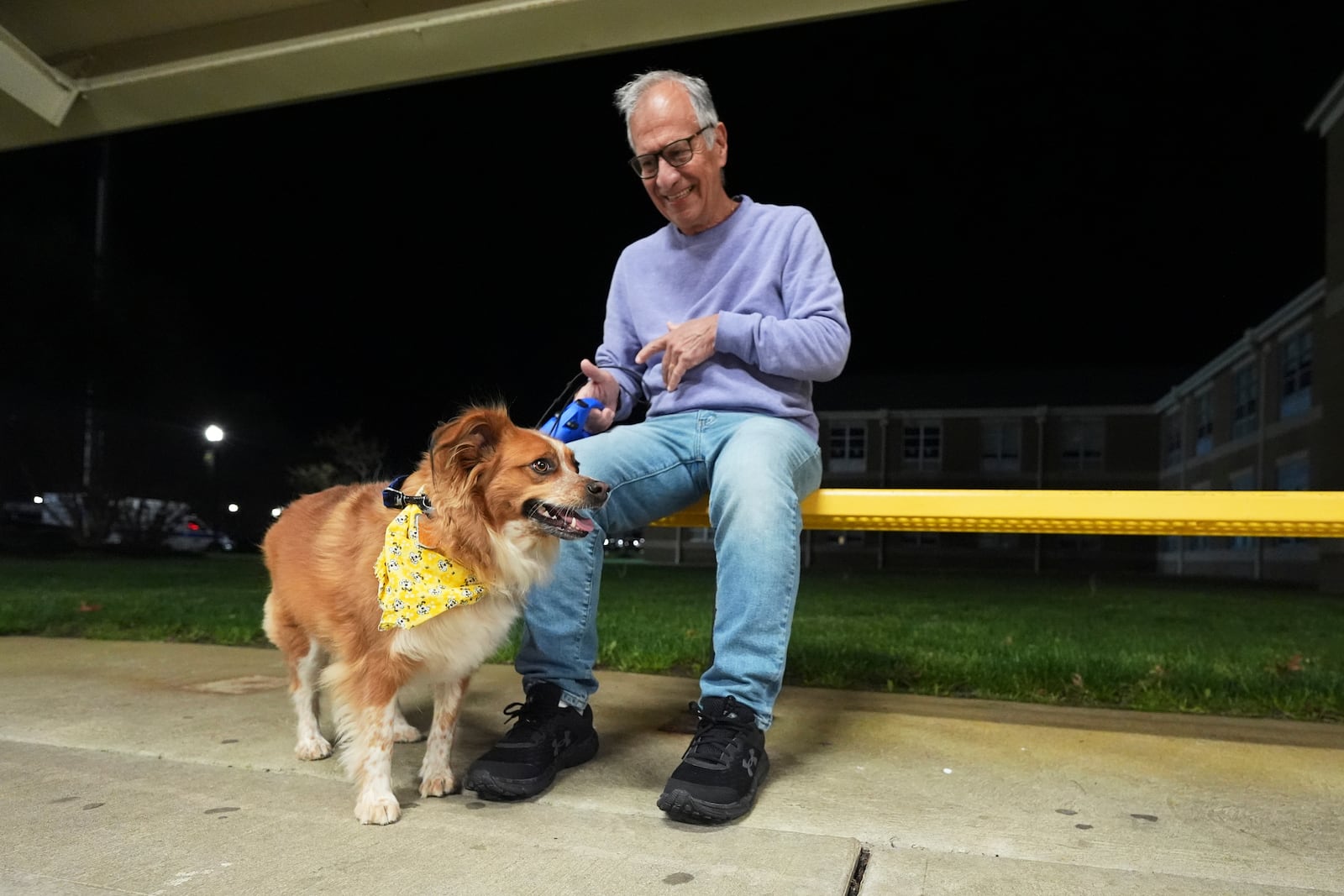 Carmine, of Waretown, and his dog Amber sit outside an evacuation center at Southern Regional High School during wildfires on Tuesday, April 22, 2025, near Stafford Township, N.J. (AP Photo/Chris Szagola)
